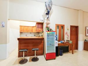 eine Küche mit einer Theke und Hockern in einem Zimmer in der Unterkunft RedDoorz Syariah near Universitas 17 Agustus Banyuwangi in Banyuwangi + 41 Fotos