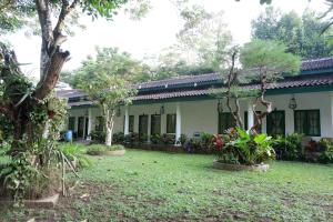 a house with trees and plants in a yard at Omah Kebon Guest House in Temanggung