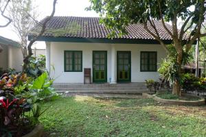 a house with green doors and a yard at Omah Kebon Guest House in Temanggung +18 photos