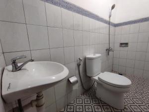 a bathroom with a toilet and a sink at Omah Kebon Guest House in Temanggung