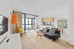 a living room with a couch and a table at Vine Apartments South Brisbane in Brisbane