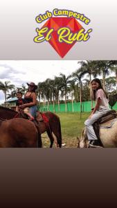 two women and a child riding on the backs of horses at Club Campestre El Rubí in Carmen de Apicalá