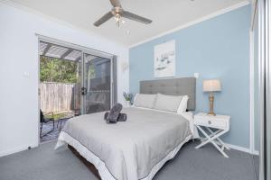 a bedroom with a bed and a ceiling fan at Private Poolside Villa in Urangan