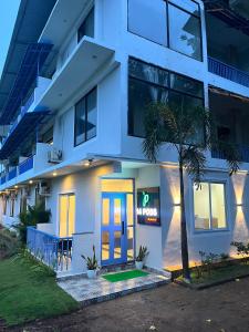 a white building with a neon sign in front of it at Hotel 14 Pods Morjim in Morjim