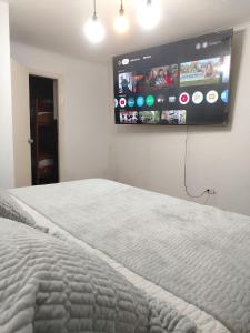 a bedroom with a bed and a flat screen tv on the wall at Casa Solé in Lima