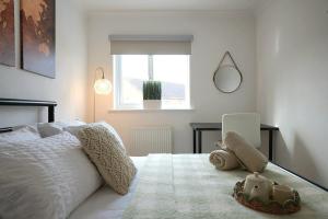 una camera da letto con un letto bianco e una finestra di Riverside Lottage Mansions a Dagenham Dock