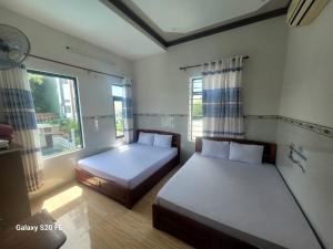 a bedroom with two beds and a window at Khách Sạn Tuấn Tú in Ninh Hải +28 photos