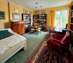 a bedroom with a bed and a desk and a table at Historic Vicarage By The Lake In Dalskog in Dalskog