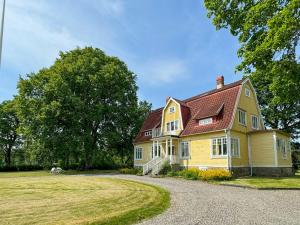 a large yellow house with a red roof at Historic Vicarage By The Lake In Dalskog in Dalskog