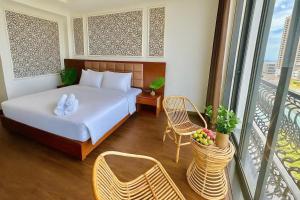 a hotel room with a bed and a balcony at Century Hotel Da Nang in Da Nang