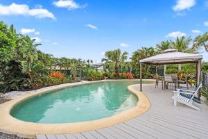 una piscina con terraza y sombrilla en The Tropics Resort Style Pool, en Urangan 20 fotos más