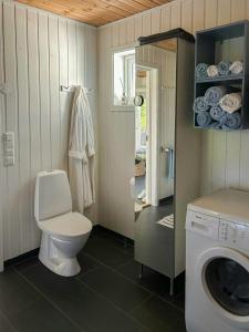 a bathroom with a toilet and a washing machine at Cabin With Views Over Straumsundet in Øygarden