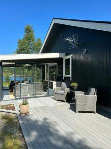 a deck with chairs and tables on a house at Cabin With Views Over Straumsundet in Øygarden