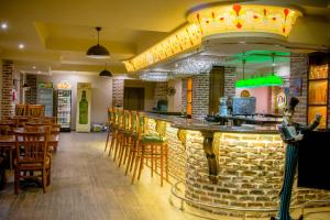 a restaurant with a bar with chairs and tables at Bristol Central Park Hotel in Chişinău +55 photos