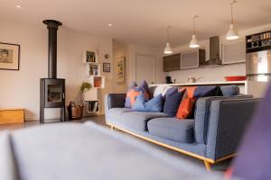 a living room with a blue couch and a stove at Lifebuoy Beach House Bicheno in Bicheno