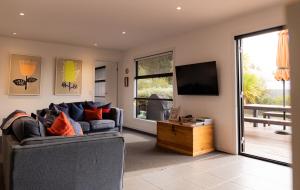 een woonkamer met een bank en een flatscreen-tv bij Lifebuoy Beach House Bicheno in Bicheno