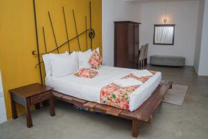 a bed with two pillows on it in a room at Clio Bolgoda in Piliyandala +24 photos