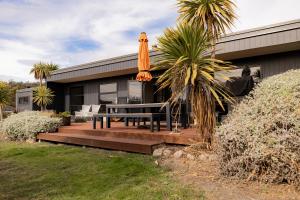 een huis met een patio met een tafel en een parasol bij Lifebuoy Beach House Bicheno in Bicheno