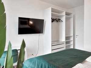 a bedroom with a bed and a tv on a wall at High Rise Balcony I Roof Top Pool I Close to Metro in Vienna