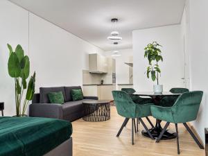a living room with a table and green chairs at High Rise Balcony I Roof Top Pool I Close to Metro in Vienna
