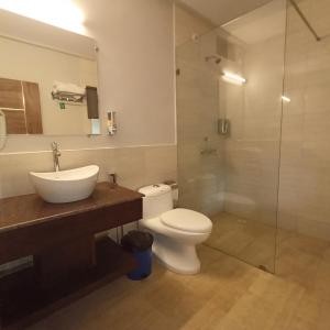a bathroom with a toilet and a sink and a shower at Hotel 14 Pods Morjim in Morjim +18 photos