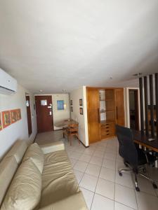un salon avec un canapé et un bureau dans l'établissement Quality suites natal apto 1009, à Natal 3 autres photos