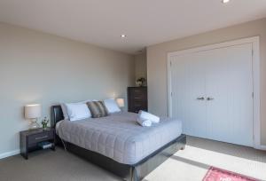 a bedroom with a bed and a large door at Pohara Heights Executive Holiday Home in Pohara