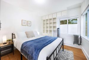 a white bedroom with a large bed and a window at Charming 2BR Roosevelt Bungalow w Quiet Yard in Seattle