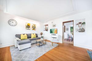 a living room with a couch and a clock on the wall at Charming 2BR Roosevelt Bungalow w Quiet Yard in Seattle +33 photos
