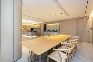 上海市にあるJI Hotel Shanghai Zhongxing Roadのキッチン(長い木製テーブル、椅子付)