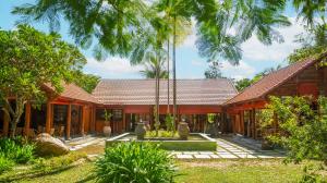 an exterior view of a house with palm trees at Furama Resort Danang in Danang +120 photos