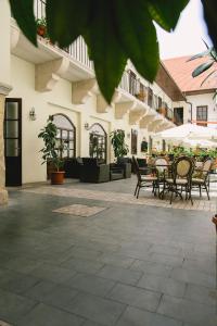 an outdoor patio with chairs and tables and umbrellas at Le Petit Paris in Cluj-Napoca