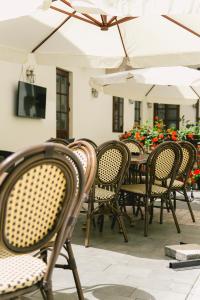 a group of chairs and tables with white umbrellas at Le Petit Paris in Cluj-Napoca