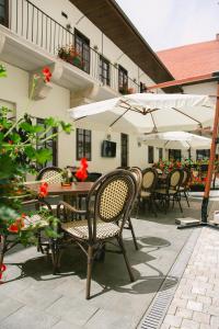 an outdoor patio with chairs and tables and umbrellas at Le Petit Paris in Cluj-Napoca