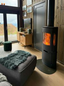 a living room with a fireplace and a ottoman in front of a room at Modern Cabin With Mountain Views In Rauland in Torvetjørn