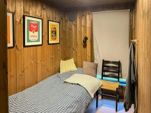 a small bedroom with a bed and a chair at Modern Cabin With Mountain Views In Rauland in Torvetjørn