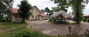 a house with a tent in the middle of a courtyard at Kartano Hostel in Kokemäki