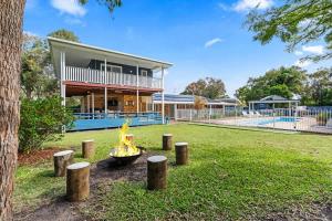 a fire pit in front of a house at Whitesands Family Beachhouse in Urangan +62 photos