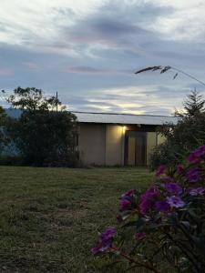 a building with purple flowers in front of it at Cabaña 23 - private cabin in Montaña Azul