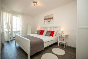 a bedroom with a large white bed with red pillows at Hendrix Bridge Apartment in Zagreb