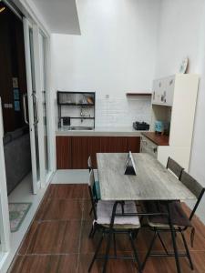 eine Küche mit Tisch und Stühlen und einem Kühlschrank in der Unterkunft Villa Dino Park Batu in Karangploso