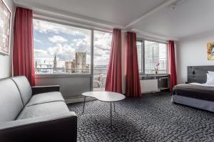 a hotel room with a bed and a large window at ProfilHotels Mercur in Copenhagen