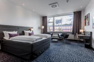 um quarto de hotel com uma cama grande e uma secretária em ProfilHotels Mercur em Copenhaga
