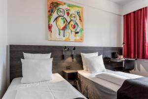 a hotel room with two beds and a painting on the wall at ProfilHotels Mercur in Copenhagen