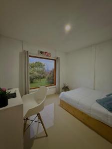 a bedroom with a bed and a desk and a window at Cabaña 23 - private cabin in Montaña Azul