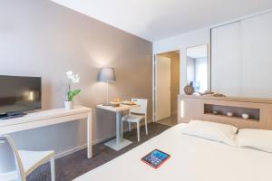 Cette chambre comprend un lit et un bureau. dans l'établissement Appart'City Classic Nantes Quais de Loire, à Nantes