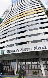 un bâtiment avec une enseigne sur la façade dans l'établissement Quality suites natal apto 1009, à Natal