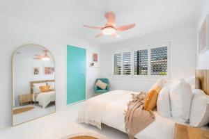 a white bedroom with a bed and a mirror at The Springs Villa 1 in Urangan +30 photos