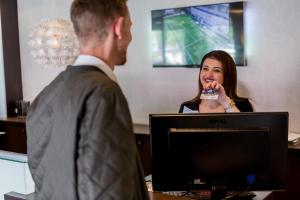 a man interviewing a woman in front of a computer at ProfilHotels Mercur in Copenhagen