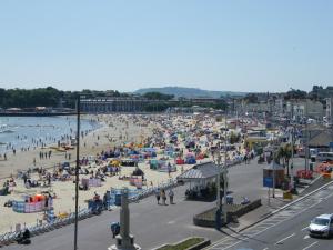 a beach with a lot of people on it at Weymouth Beach B&B - Adult Only in Weymouth